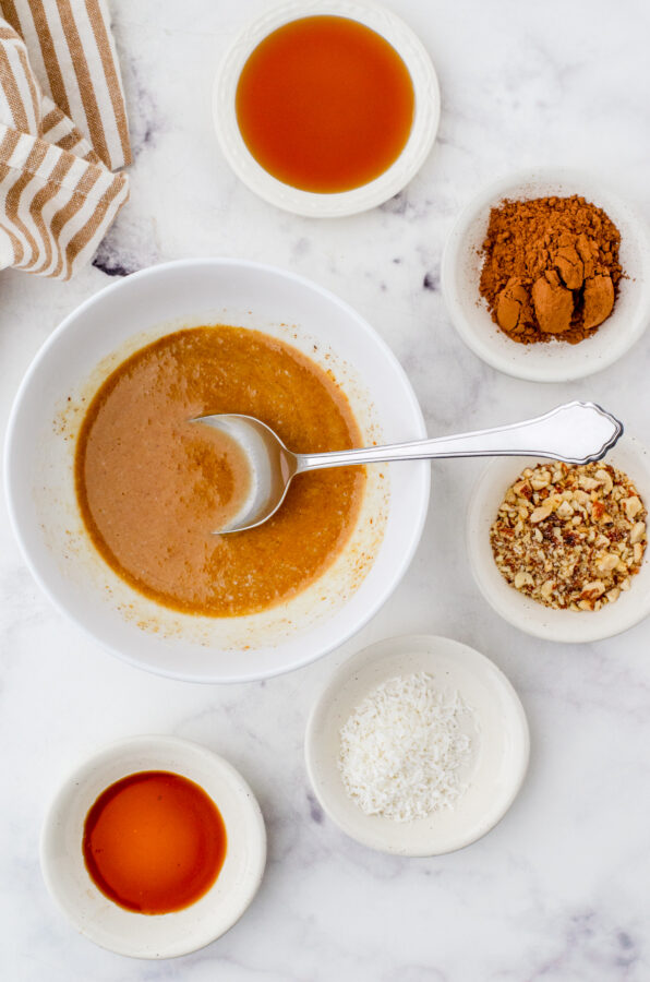 Melted base for these almond butter chocolate cups with all the add ins beside it.