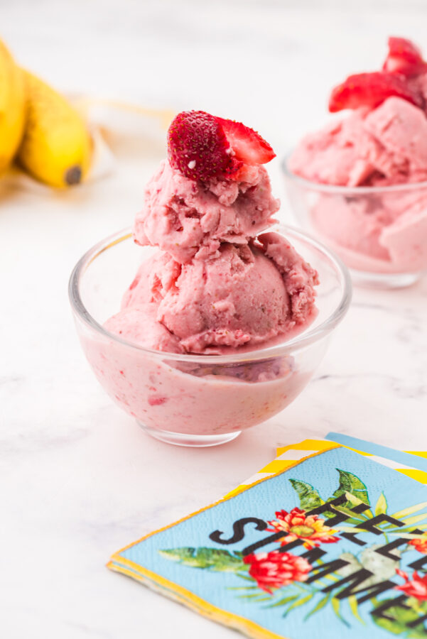 Bowl of frozen yogurt with a strawberry on top.