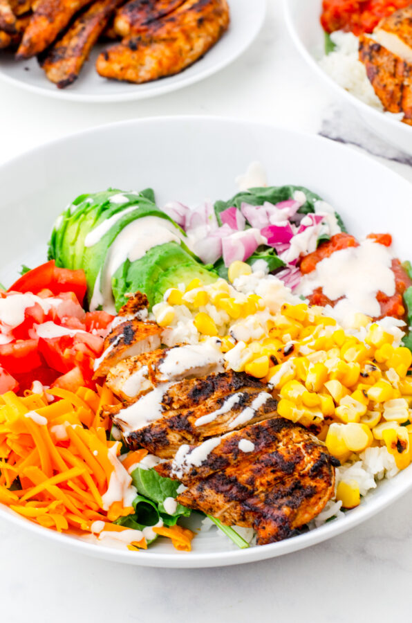 a mexican chicken rice bowl with sauce drizzled over the top