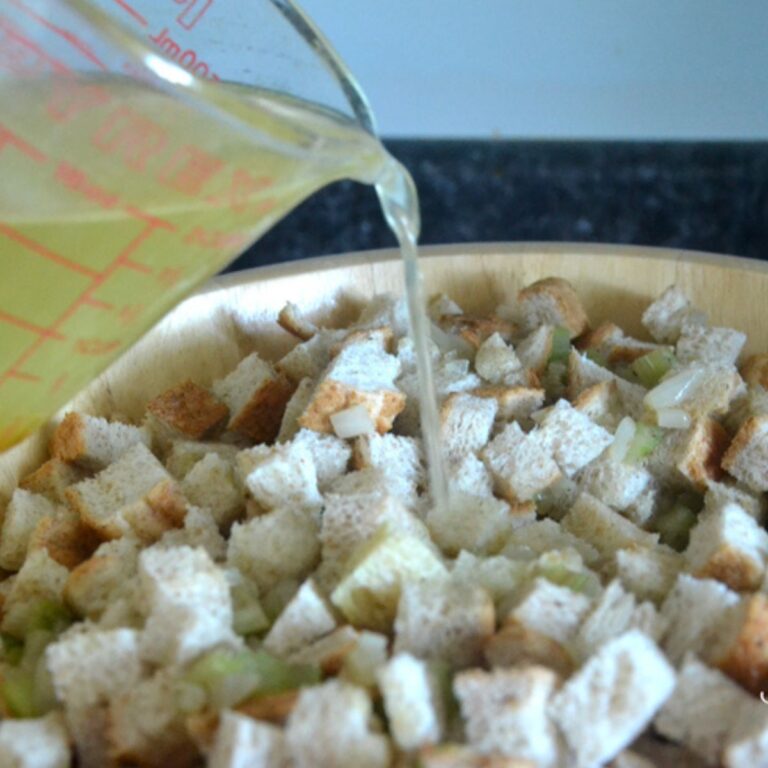 broth being poured into old fashioned stuffing mixture