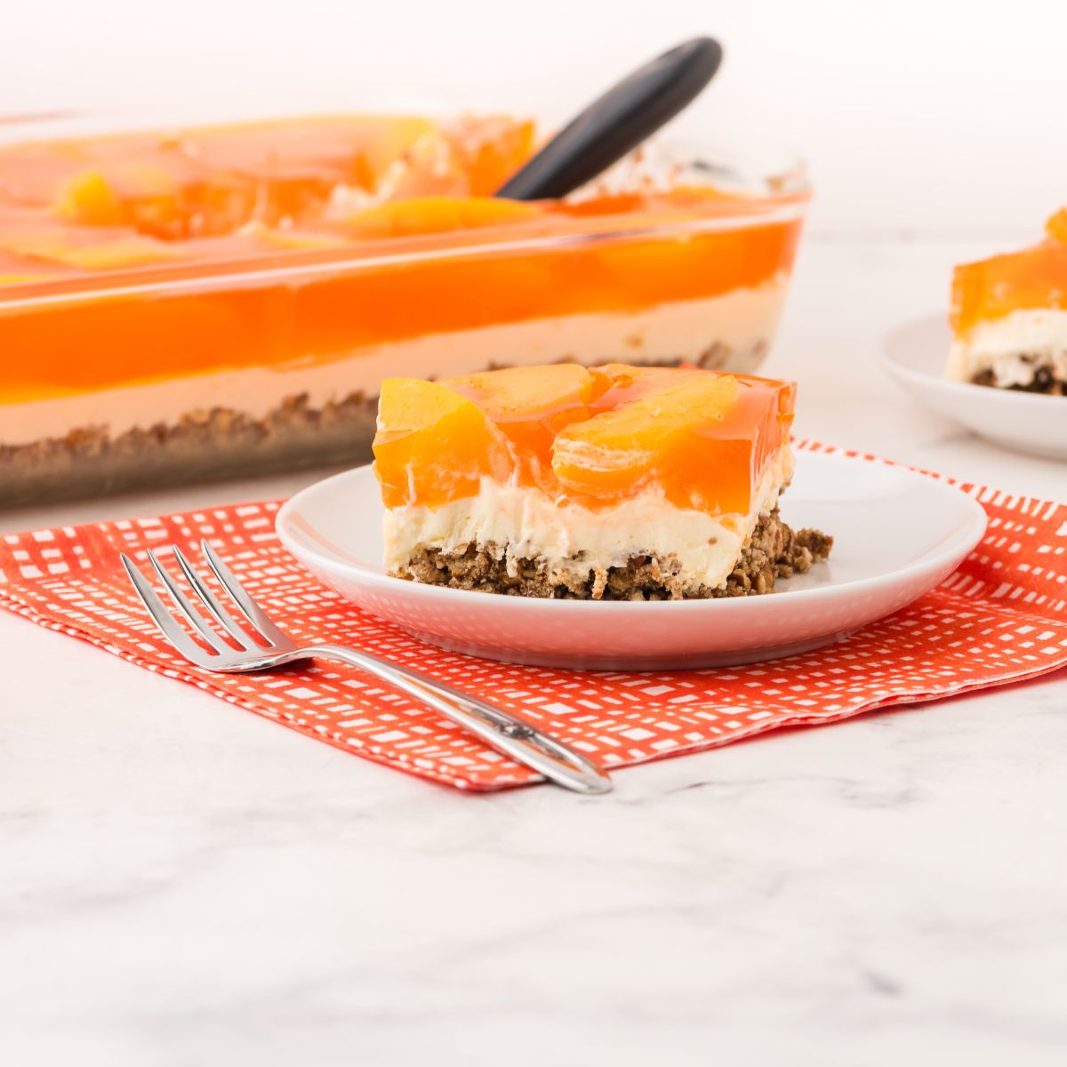 A slice of peach pretzel salad on a serving plate