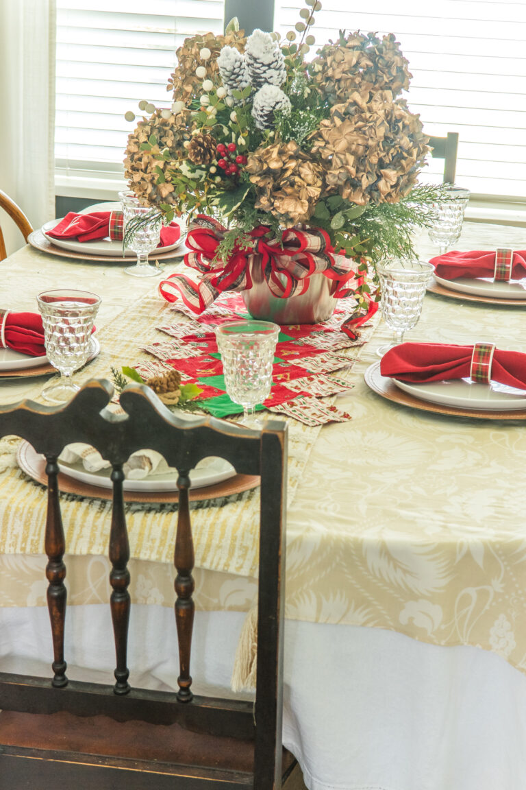 A christmas table set with red napkins and a large centerpiece