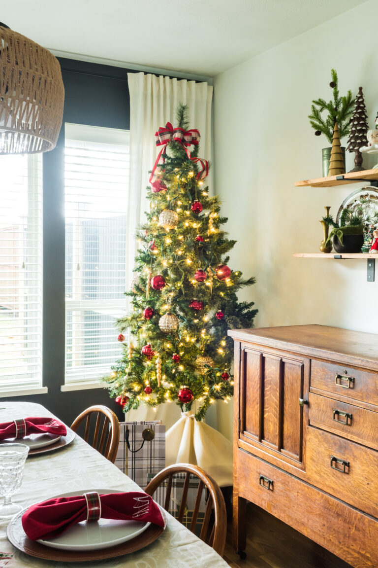Christmas tree on a box beside and antique buffet