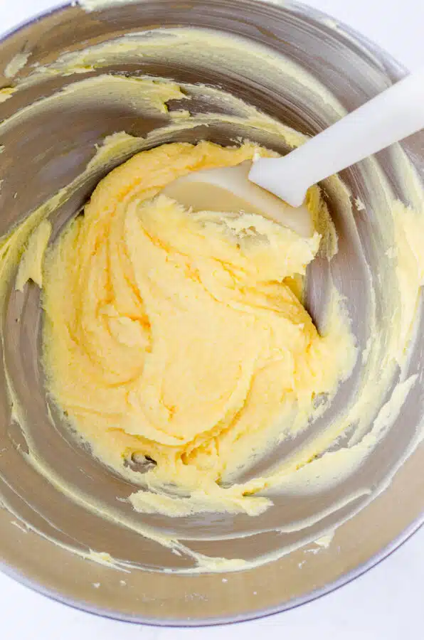 The ingredients for the middle layer of nanaimo bars whipped together in the bowl of a stand mixer.